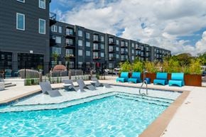 Nashville apartment for rent - A swimming pool with lounge chairs in front of a building.
