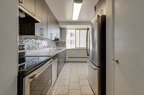 Edmonton apartment for rent - a kitchen with white cabinets and a stainless steel refrigerator