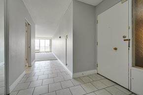 Edmonton apartment for rent - an empty hallway with white walls and a tiled floor