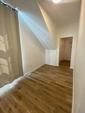Louisville apartment for rent - A room with wooden flooring and a door on the right side.