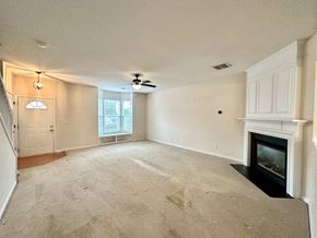 Greer house for rent - A living room with a fireplace and a ceiling fan.