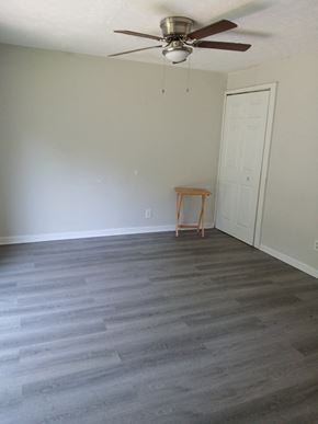 Clarksville apartment for rent - an empty living room with wood floors and a ceiling fan