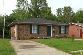 Clarksville apartment for rent - a small brick house with green doors and a driveway