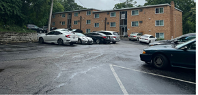 Cincinnati apartment for rent - A parking lot with cars and a building in the background.
