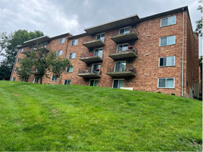 Cincinnati apartment for rent - A red brick apartment building with green grass in front.