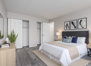 Cincinnati apartment for rent - A bedroom with a large bed and a wooden dresser.