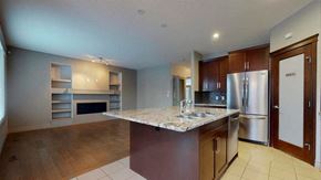 Edmonton house for rent - a kitchen with a marble counter top and a refrigerator
