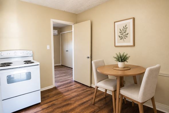 Knoxville apartment for rent - A kitchen with a white stove and a dining table with two chairs.