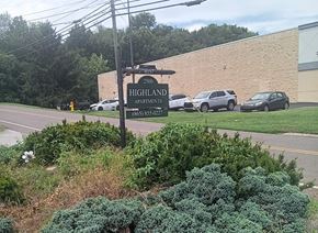 Knoxville apartment for rent - A sign for Highland Apartments stands in front of a building.