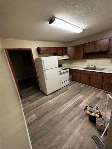 Knoxville apartment for rent - A kitchen with a white fridge and wooden cabinets.
