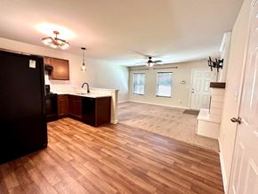 Greenville house for rent - A kitchen with a black refrigerator and wooden floors.