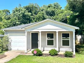 Greenville house for rent - A small house with a grey and white exterior and a black door.