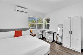 Miami apartment for rent - A bedroom with a large bed and a desk with a chair.