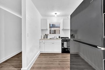 Miami apartment for rent - A kitchen with white cabinets and a black refrigerator.