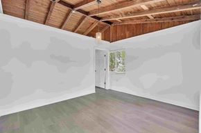 Miami apartment for rent - A room with a wooden ceiling and a door leading to a balcony.