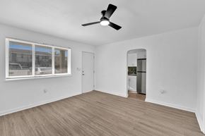Miami apartment for rent - A room with a ceiling fan and a window with blinds.