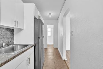 Miami apartment for rent - A kitchen with white cabinets and a stainless steel refrigerator.