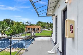Miami apartment for rent - a balcony with a view of a pool and a building