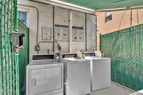 Miami apartment for rent - A green fence surrounds a washing machine and dryer.