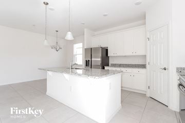 Bartow house for rent - a white kitchen with white cabinets and a marble counter top