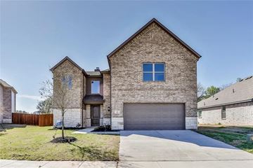 Azle house for rent - A house with a garage and a tree in front.