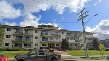 New Westminster apartment for rent - A grey truck is parked in front of a multi-story apartment building.