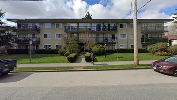 New Westminster apartment for rent - A person is walking on a sidewalk in front of a building.