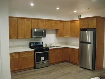 Reseda apartment for rent - A kitchen with wooden cabinets and stainless steel appliances.