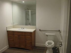 Reseda apartment for rent - A white toilet sits in a bathroom next to a sink and a mirror.
