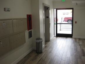 Reseda apartment for rent - A hallway with a trash can and a door leading to a parking lot.