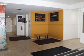 Vancouver apartment for rent - A hallway with a bench and a fire extinguisher.