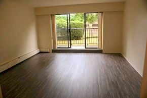 Vancouver apartment for rent - A room with a sliding glass door leading to a backyard.