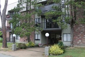 Vancouver apartment for rent - A building with a balcony and a small garden in front.