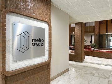 Houston apartment for rent - A sign that says Metro Spaces is mounted on a brick wall.