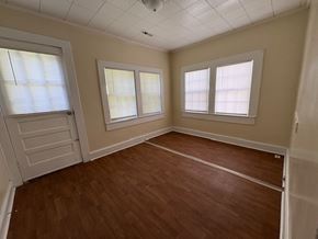 Stantonsburg house for rent - A room with wooden floors and three windows.