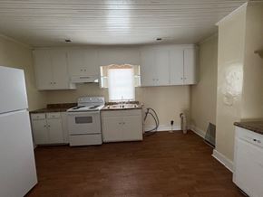 Stantonsburg house for rent - A kitchen with white appliances and wooden floors.