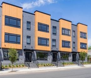 Newark apartment for rent - A row of modern townhouses with orange and grey exteriors.