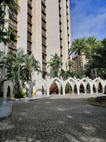Honolulu apartment for rent - a courtyard with palm trees and a tall building