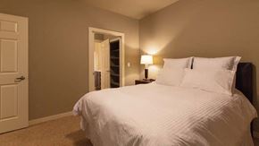 Papillion apartment for rent - a bedroom with a large white bed and a door