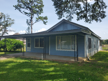 Deridder house for rent - the front of a blue house with a porch