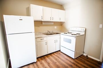 Knoxville apartment for rent - A white fridge and oven in a kitchen with wooden floors.