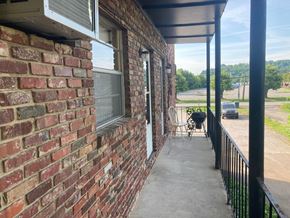Knoxville apartment for rent - A patio with a black railing and a brick wall.