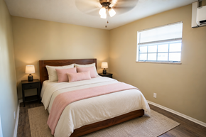 Knoxville apartment for rent - A bedroom with a bed, two lamps, and a window.