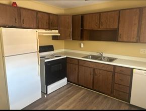 Knoxville apartment for rent - A kitchen with a white fridge and a black oven.