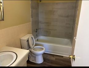 Knoxville apartment for rent - A white toilet sits next to a bathtub in a bathroom.