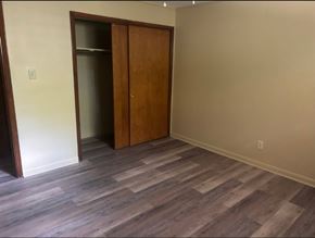 Knoxville apartment for rent - A room with a wooden floor and a wall-mounted closet.