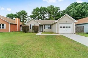 Jacksonville house for rent - a white house with a yard and a white garage door