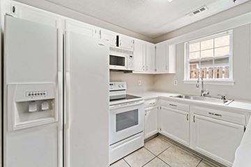 Jacksonville house for rent - a kitchen with white appliances and white cabinets