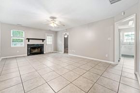 Jacksonville house for rent - an empty living room with a fireplace and tiled flooring