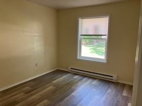 Xenia apartment for rent - A room with a window and a wooden floor.